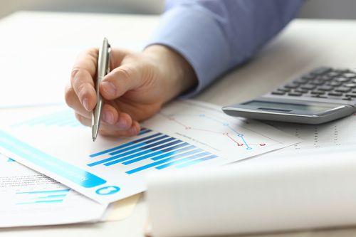 Person zeigt mit Stift auf Akten